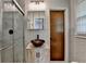 Updated bathroom featuring a glass shower, decorative sink and wood-look cabinets at 2963 Williams Pl, Snellville, GA 30078