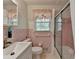 Pink bathroom featuring a vanity sink, toilet, and glass enclosed shower/tub at 2963 Williams Pl, Snellville, GA 30078