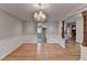 Dining area with hardwood floors, wainscoting detail, and an arched entrance leading to kitchen and living area at 2963 Williams Pl, Snellville, GA 30078