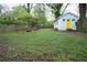 Large backyard with a swing set, fire pit, fence, and a charming cottage with a yellow door at 3078 Semmes St, East Point, GA 30344