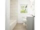 Bathroom featuring gray vanity, white tile, and a tub at 3078 Semmes St, East Point, GA 30344