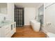 Bright bathroom featuring a modern vanity, freestanding tub, and a shower with a dark grid-pane enclosure at 3078 Semmes St, East Point, GA 30344