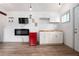A functional kitchenette with white cabinets, a retro mini-fridge, electric fireplace and a mounted TV at 3078 Semmes St, East Point, GA 30344