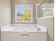 Soaking tub with a large window offering an outdoor view at 3499 Henderson Reserve, Atlanta, GA 30341