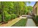 Lush backyard with mature trees and greenery, a built-in spa, brick patio, and a dining set at 385 Laurel Chase Ct, Atlanta, GA 30327