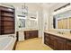 Bathroom featuring tiled floors, double vanity, built-in shelves and cabinets, and a soaking tub at 385 Laurel Chase Ct, Atlanta, GA 30327