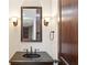 Elegant powder room featuring a decorative mirror and sconces, complemented by a stylish sink and fixtures at 385 Laurel Chase Ct, Atlanta, GA 30327