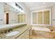 Bathroom featuring granite countertop vanity, soaking tub, and a large window at 385 Laurel Chase Ct, Atlanta, GA 30327