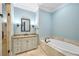 Bright bathroom with tile flooring, soaking tub, granite countertops and walk-in shower at 385 Laurel Chase Ct, Atlanta, GA 30327