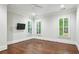 Bright bedroom featuring beautiful hardwood floors, a ceiling fan, and natural light from shuttered windows at 385 Laurel Chase Ct, Atlanta, GA 30327