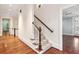 Hallway featuring wood floors and a staircase with carpeted steps and a wooden railing at 385 Laurel Chase Ct, Atlanta, GA 30327