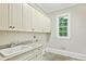Laundry room with tile floors, cabinets, sink and window at 385 Laurel Chase Ct, Atlanta, GA 30327