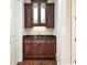 A conveniently located wet bar features sleek dark cabinets, a dark granite countertop, and hardwood floors at 385 Laurel Chase Ct, Atlanta, GA 30327
