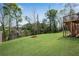 Backyard features a well-maintained lawn, a black metal fence, and trees in the background at 3950 Grandview Manor Dr, Cumming, GA 30028