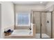 Primary bathroom featuring soaking tub, tiled walk-in shower and natural light from window at 3950 Grandview Manor Dr, Cumming, GA 30028