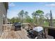 A wooden deck with a grill, potted plants, and a view of trees and green fields at 3950 Grandview Manor Dr, Cumming, GA 30028