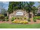 Stone community entrance sign with manicured landscaping and colorful flower beds at 3950 Grandview Manor Dr, Cumming, GA 30028
