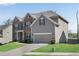 Side view of two-story home with brick and gray siding, showcasing a neatly landscaped lawn and driveway at 3950 Grandview Manor Dr, Cumming, GA 30028