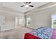 Spacious primary bedroom featuring tray ceiling, carpet and natural light from the windows at 3950 Grandview Manor Dr, Cumming, GA 30028
