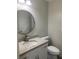 A stylish powder room with a granite countertop, modern faucet, and round mirror at 3899 Leach Rd, Snellville, GA 30039