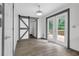 Bright bedroom with sliding barn door, access to deck, and wood-look flooring at 3899 Leach Rd, Snellville, GA 30039