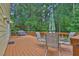 Home's wooden deck features outdoor furniture, grill and tree lined views at 3899 Leach Rd, Snellville, GA 30039