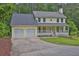Charming yellow two-story home featuring a two-car garage and a covered front porch at 3899 Leach Rd, Snellville, GA 30039