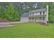 Inviting yellow home boasts a two-car garage, covered porch, and a lush front lawn at 3899 Leach Rd, Snellville, GA 30039