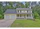 Charming two-story home with a welcoming front porch and a two-car garage at 3899 Leach Rd, Snellville, GA 30039