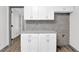 Kitchenette area with white cabinets, granite countertop, and gray backsplash at 3899 Leach Rd, Snellville, GA 30039