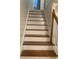 Wooden staircase with white risers and a dark wood handrail at 3899 Leach Rd, Snellville, GA 30039