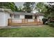 A charming home featuring a white brick facade, black trim, and a lovely, light wood slat front porch at 3207 Bobbie Ln, Decatur, GA 30032