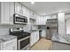 Updated kitchen with stainless steel appliances, granite countertops, white cabinets, and modern backsplash at 3207 Bobbie Ln, Decatur, GA 30032