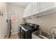 Practical laundry room with sink, washer, dryer, and ample storage at 3295 Millwood Se Trl, Smyrna, GA 30080