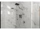 Luxurious walk-in shower featuring marble walls, dual shower heads, and built-in niche for added convenience at 3295 Millwood Se Trl, Smyrna, GA 30080