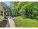 Lush backyard featuring green grass, mature trees, and a sidewalk leading to the back at 3982 Battleford Ct, Atlanta, GA 30341