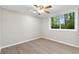 Bedroom with light wood flooring, neutral paint, and a large window overlooking a private yard at 3982 Battleford Ct, Atlanta, GA 30341