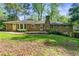 Brick ranch-style home with manicured lawn and mature trees providing shade in the front yard at 3982 Battleford Ct, Atlanta, GA 30341