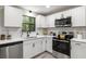 Bright kitchen features white cabinets, stainless steel appliances, and quartz countertops at 4983 Needle Knob Ct, Lithonia, GA 30038