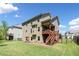 Multi-story home with a backyard patio and well-maintained lawn on a sunny day at 5780 Winding Lakes Dr, Cumming, GA 30028