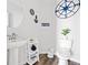 Stylish half-bathroom with nautical-themed decor, white fixtures, and hardwood floors at 5780 Winding Lakes Dr, Cumming, GA 30028