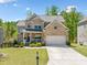 Charming two-story brick home with a well-manicured lawn and a two-car garage at 5780 Winding Lakes Dr, Cumming, GA 30028