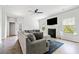 Comfortable living room with a gray sofa, decorative fireplace, ceiling fan, and hardwood floors at 5780 Winding Lakes Dr, Cumming, GA 30028