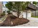 View of a backyard with a wooden bench near the mulch and the back of two garages at 2238 Parkview Nw Ct, Atlanta, GA 30318