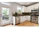 Modern kitchen featuring stainless steel appliances, white cabinets, and a door leading to an outdoor deck at 2238 Parkview Nw Ct, Atlanta, GA 30318