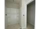 Bright bathroom with a white shower stall featuring built-in shelving next to doorway at 4556 Sweetlake Sw Ct, Mableton, GA 30126