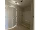 Bathroom featuring a white shower with built-in shelving and double-door closet for storage at 4556 Sweetlake Sw Ct, Mableton, GA 30126