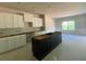 New kitchen featuring white cabinets, black island, and natural light from a large window at 4556 Sweetlake Sw Ct, Mableton, GA 30126