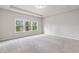 Spacious bedroom featuring tray ceiling, three large windows, and neutral paint colors at 4531 Claiborne Ct, Duluth, GA 30096