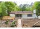 View of the home's backyard with a new wooden deck and brick exterior with black trim at 6881 Homestead Rd, Rex, GA 30273